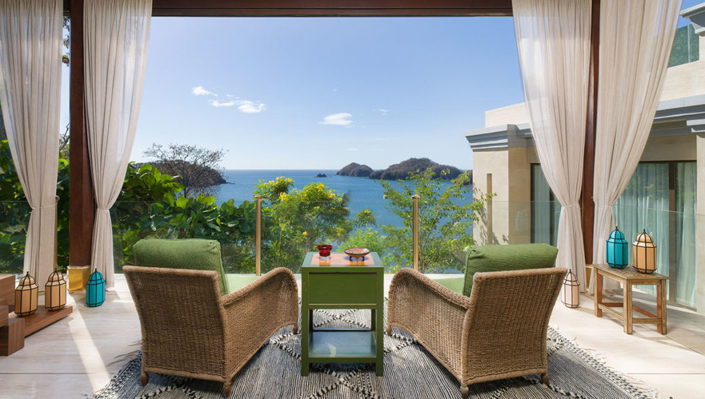Two chairs and a table pointed to a sew view in The Hive Private Residence living room area